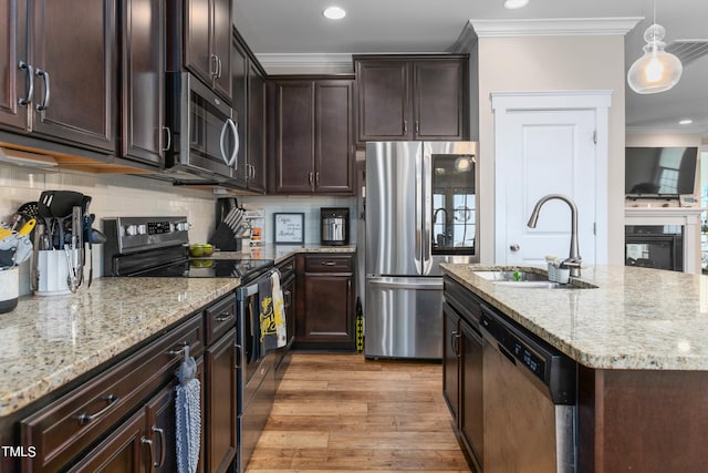 kitchen with ornamental molding, sink, decorative light fixtures, light hardwood / wood-style flooring, and appliances with stainless steel finishes