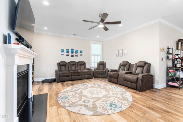 living room featuring wood-type flooring, ornamental molding, and ceiling fan