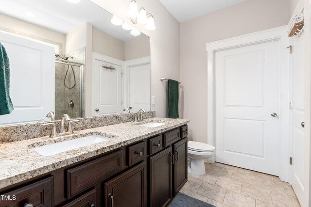 bathroom featuring tile patterned flooring, vanity, toilet, and an enclosed shower