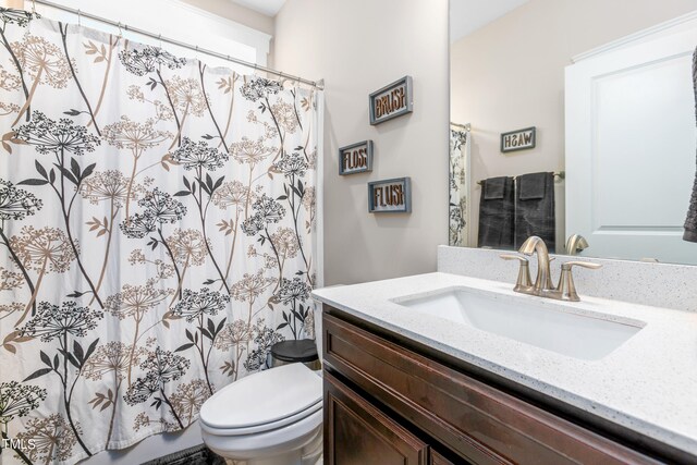 bathroom with walk in shower, vanity, and toilet