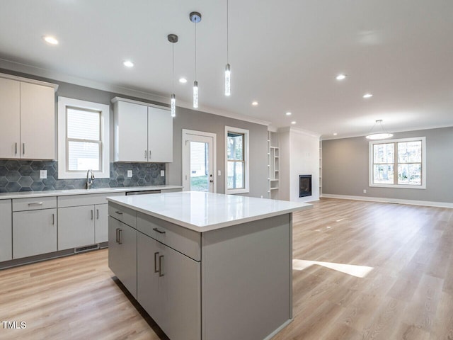 kitchen with pendant lighting, a center island, light hardwood / wood-style floors, and a wealth of natural light