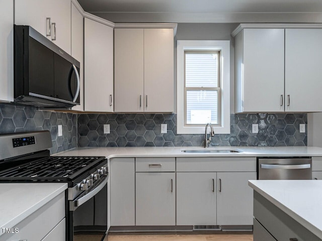 kitchen with appliances with stainless steel finishes, backsplash, and sink