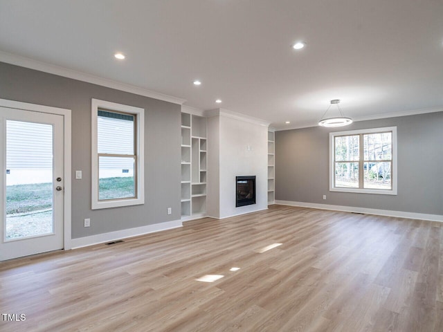 unfurnished living room with a wealth of natural light, crown molding, and light hardwood / wood-style floors