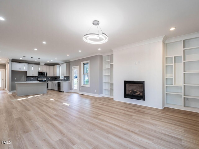 unfurnished living room with crown molding and light hardwood / wood-style flooring