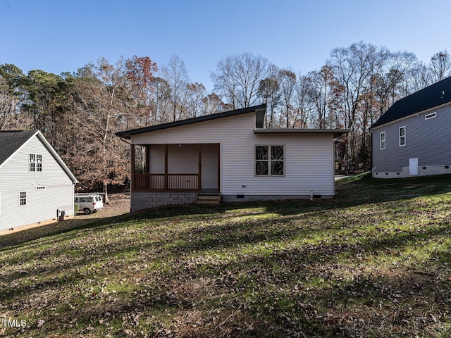 rear view of property with a lawn and a porch