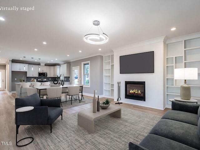 living room featuring light wood-type flooring and ornamental molding