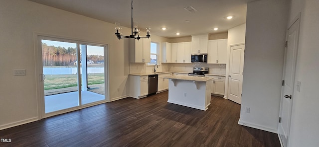 kitchen with sink, white cabinetry, a center island, appliances with stainless steel finishes, and pendant lighting