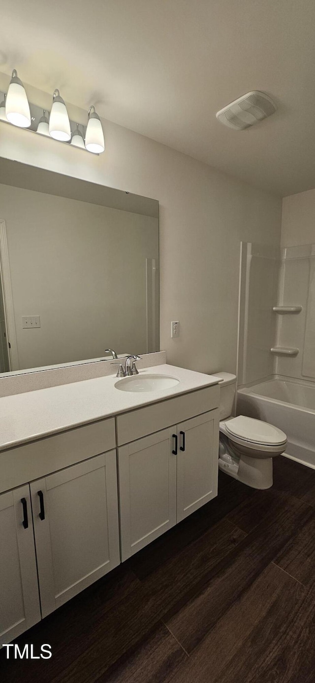 full bathroom featuring toilet, wood-type flooring, bathtub / shower combination, and vanity