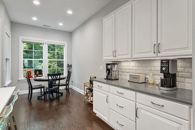 kitchen featuring white cabinetry, dark wood-type flooring, and backsplash