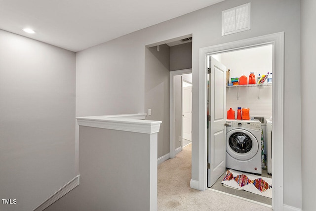 clothes washing area with light colored carpet and washing machine and clothes dryer