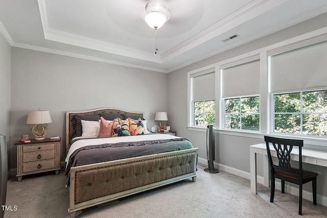 carpeted bedroom featuring multiple windows, a raised ceiling, ornamental molding, and ceiling fan