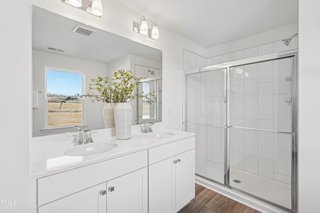 bathroom with vanity, hardwood / wood-style flooring, and a shower with shower door