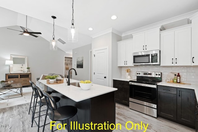 kitchen with tasteful backsplash, an island with sink, appliances with stainless steel finishes, and white cabinets