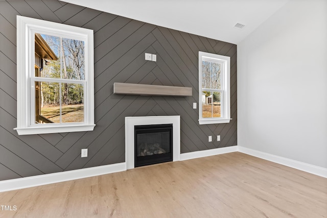 unfurnished living room featuring wood-type flooring and a fireplace