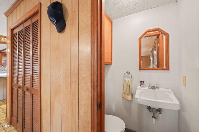 bathroom with sink, a textured ceiling, and toilet