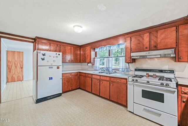 kitchen with sink, white appliances, and a textured ceiling