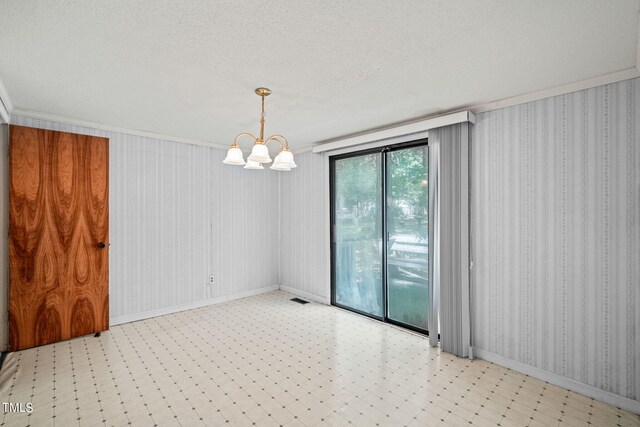 spare room with a textured ceiling, a chandelier, and crown molding