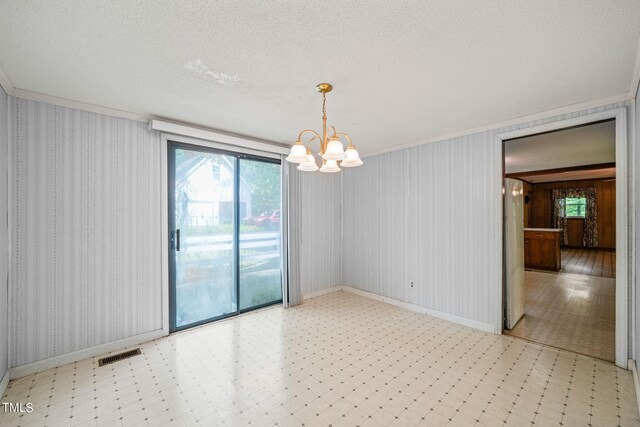 unfurnished room with a textured ceiling, an inviting chandelier, and ornamental molding