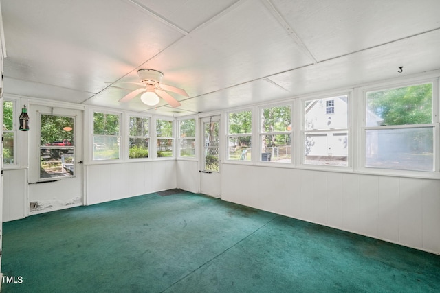 unfurnished sunroom featuring ceiling fan and plenty of natural light