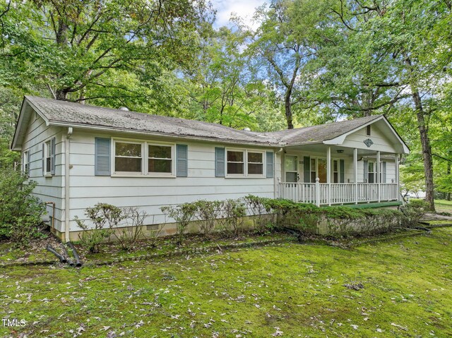 single story home with covered porch and a front yard