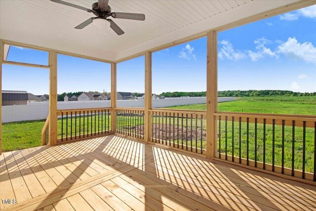 wooden terrace featuring ceiling fan and a yard