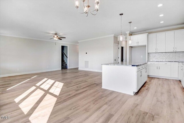 kitchen with a center island, ceiling fan with notable chandelier, white cabinetry, light hardwood / wood-style flooring, and decorative light fixtures