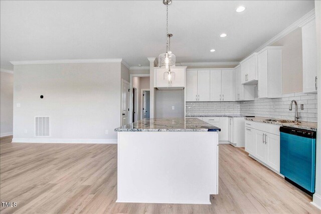 kitchen with dishwasher, sink, white cabinetry, a kitchen island, and light hardwood / wood-style flooring