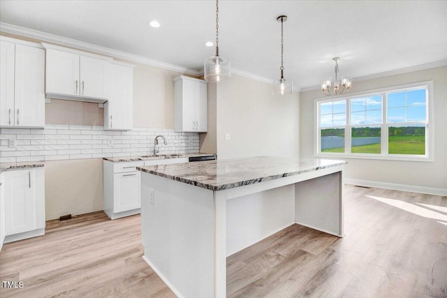 kitchen with white cabinets, light wood-type flooring, and a kitchen island