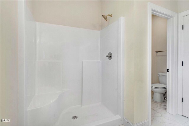 bathroom featuring walk in shower and toilet