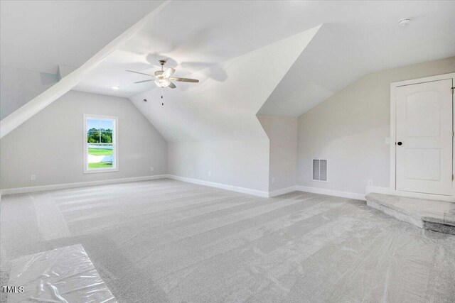 additional living space with lofted ceiling, light carpet, and ceiling fan