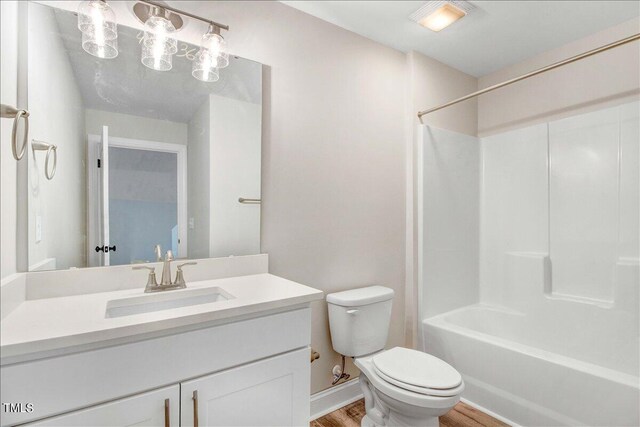 full bathroom with washtub / shower combination, vanity, toilet, and hardwood / wood-style flooring