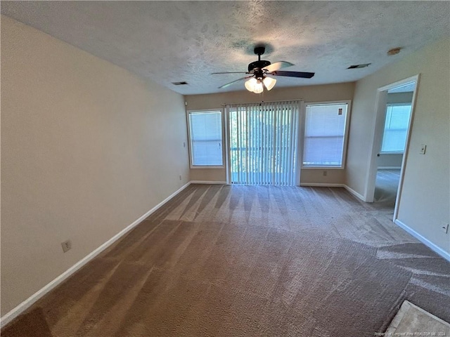 unfurnished room featuring ceiling fan, a textured ceiling, carpet flooring, and a healthy amount of sunlight