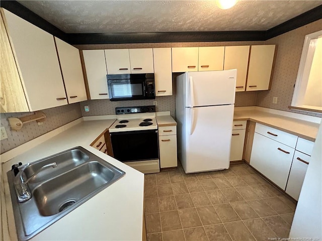 kitchen with a textured ceiling, white appliances, and sink