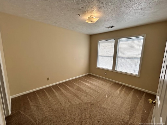 empty room featuring a textured ceiling and carpet