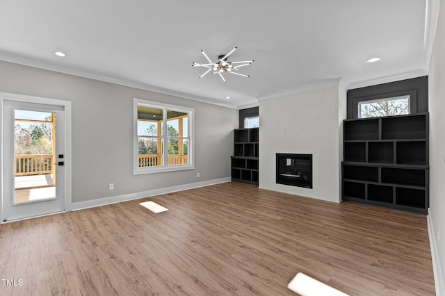 unfurnished living room featuring wood-type flooring and ornamental molding