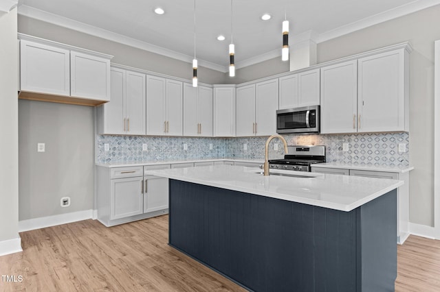 kitchen with hanging light fixtures, crown molding, appliances with stainless steel finishes, light hardwood / wood-style floors, and white cabinetry