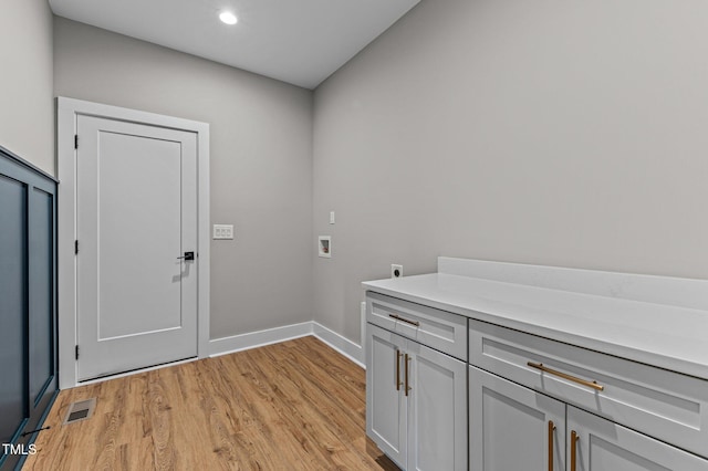 laundry area featuring hookup for an electric dryer, cabinets, hookup for a washing machine, and light hardwood / wood-style flooring