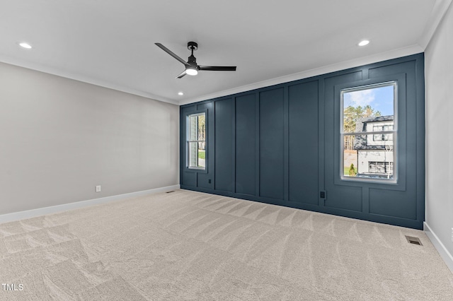 unfurnished room featuring ceiling fan, light colored carpet, and ornamental molding