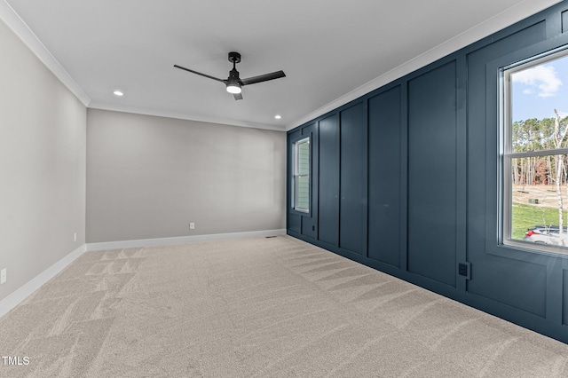 spare room featuring light carpet, ceiling fan, and ornamental molding