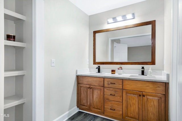 bathroom with built in shelves, vanity, and wood-type flooring