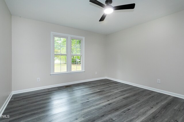 empty room with dark hardwood / wood-style flooring and ceiling fan