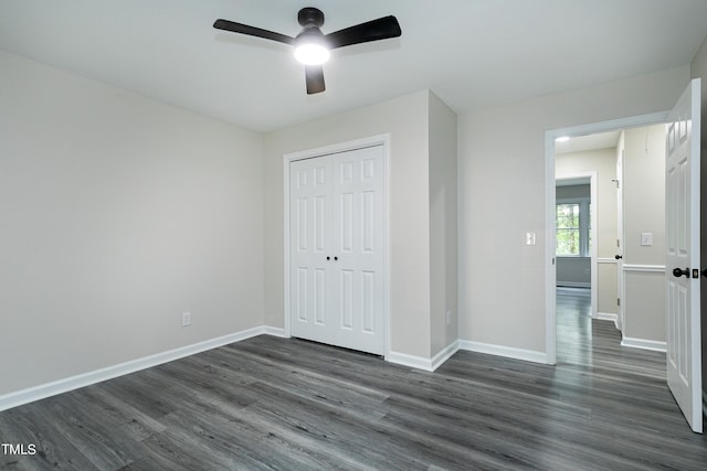 unfurnished bedroom with dark hardwood / wood-style flooring, a closet, and ceiling fan