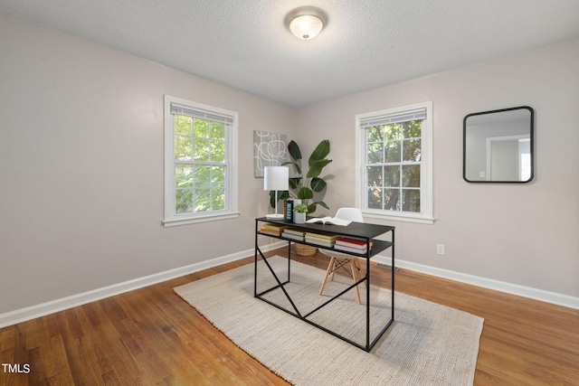 office space with wood-type flooring and a textured ceiling