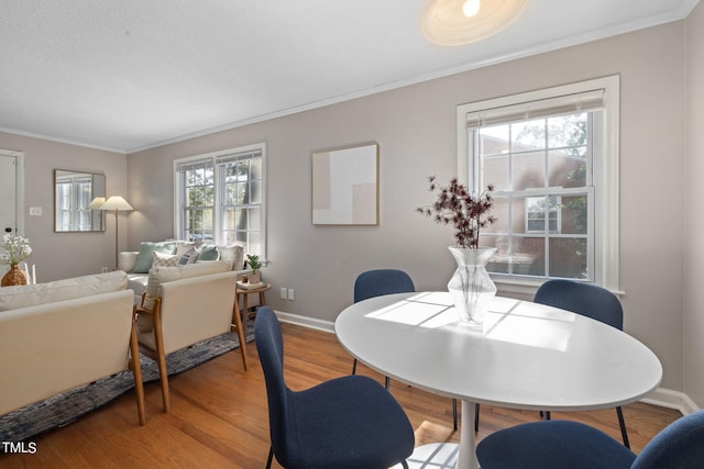 dining room with hardwood / wood-style flooring and ornamental molding