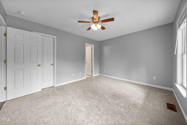 unfurnished bedroom featuring carpet floors, a textured ceiling, and ceiling fan