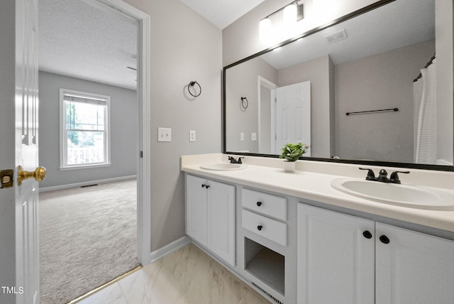 bathroom with a textured ceiling and vanity