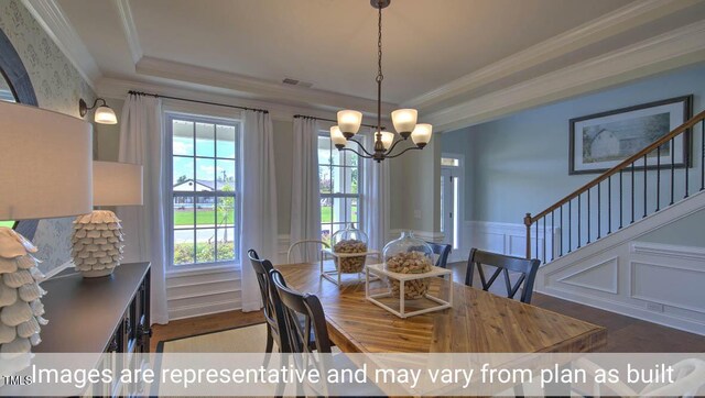 dining space with ornamental molding, an inviting chandelier, dark wood-type flooring, and plenty of natural light