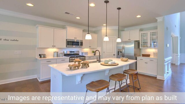 kitchen with a kitchen island with sink, stainless steel appliances, and white cabinets