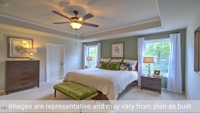 bedroom with ceiling fan, light colored carpet, a raised ceiling, and ornamental molding