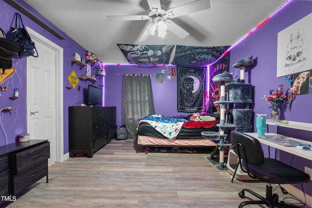 bedroom featuring ceiling fan, a textured ceiling, and light hardwood / wood-style flooring